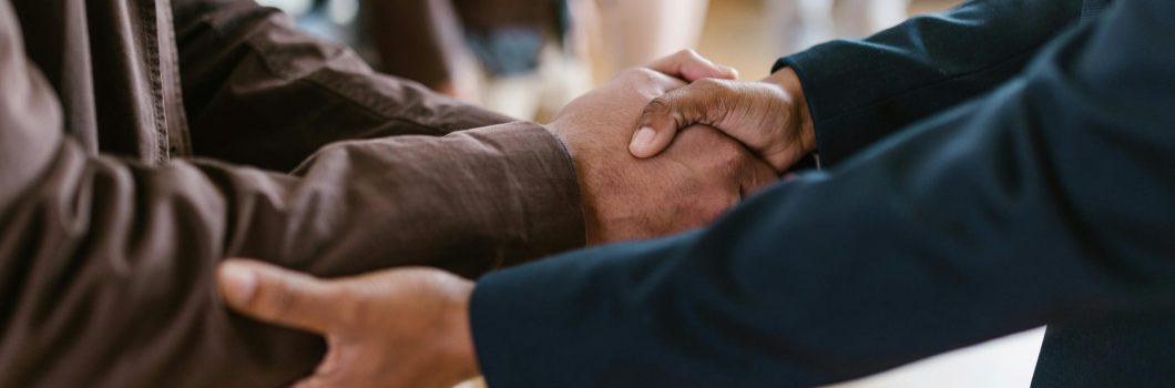Close-up of two businesspeople shaking hands, symbolizing agreement and partnership.
